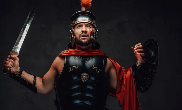 Roman champion with armour and red cloak in dark background — Stock Photo, Image