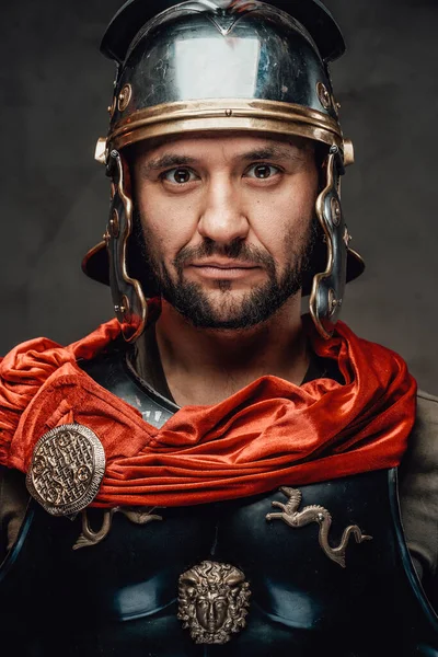 Římský voják zírá do kamery v tmavém pozadí — Stock fotografie