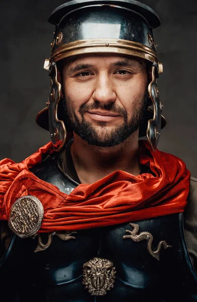 Joyful roman warrior looking at camera in dark background — Stock Photo, Image