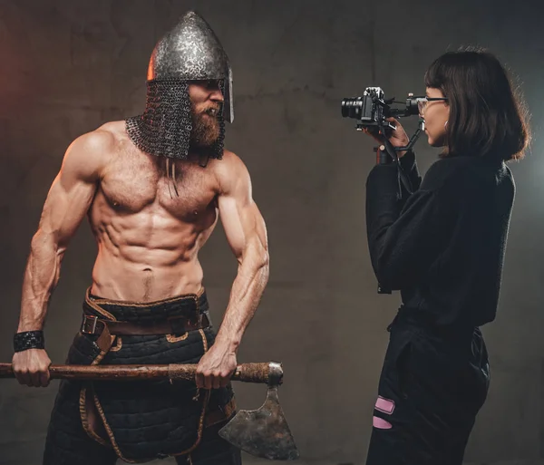 Naked guy with axe in fashion of viking poses for camera