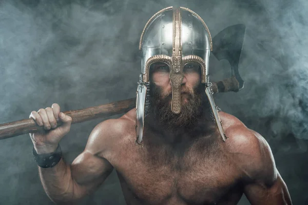 Viking poserar i rök med yxa bakom ryggen — Stockfoto