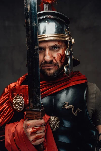 Серйозний солдат з Риму тримає меч на задньому плані — стокове фото