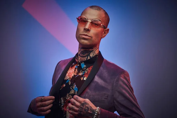 Hombre con estilo en chaqueta personalizada con gafas posa en el estudio — Foto de Stock