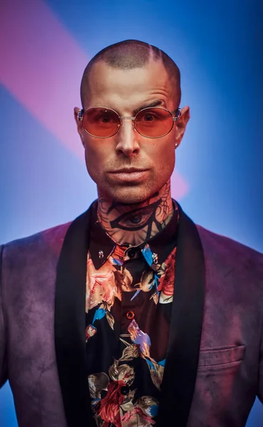 Hombre con estilo en chaqueta personalizada con gafas posa en el estudio — Foto de Stock