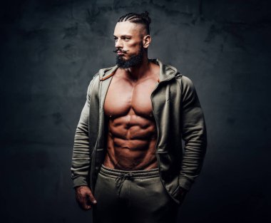 Handsome bodybuilder with naked torso in gray sportswear clipart