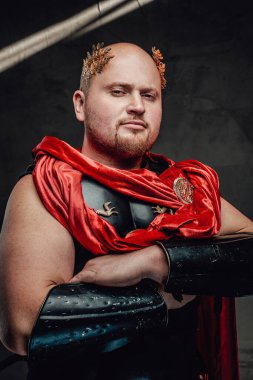 Kel Romalı savaşçı, arka planda çapraz kollarla poz veriyor.