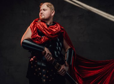 Stüdyoda kılıçlı, tüysüz, savaşçı Romalı pozu.