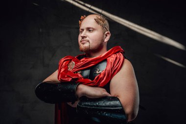 Kel Romalı savaşçı, arka planda çapraz kollarla poz veriyor.