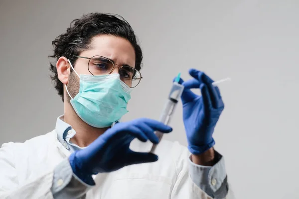 Médico com máscara e luvas em laboratório prepara seringa — Fotografia de Stock