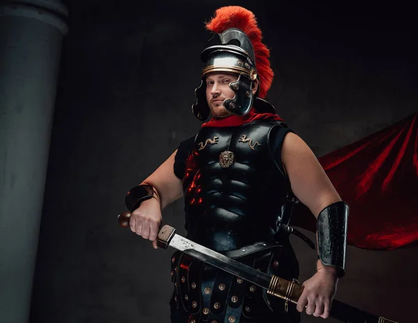 Poses legionárias com espada embainhada em fundo escuro — Fotografia de Stock