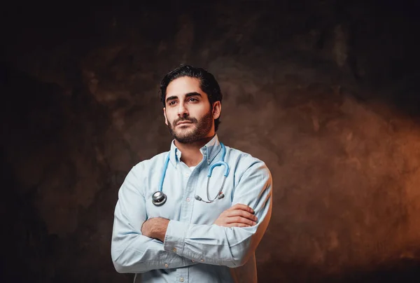 Skilled doctor with beard and white labcoat in dark background — Stock Photo, Image