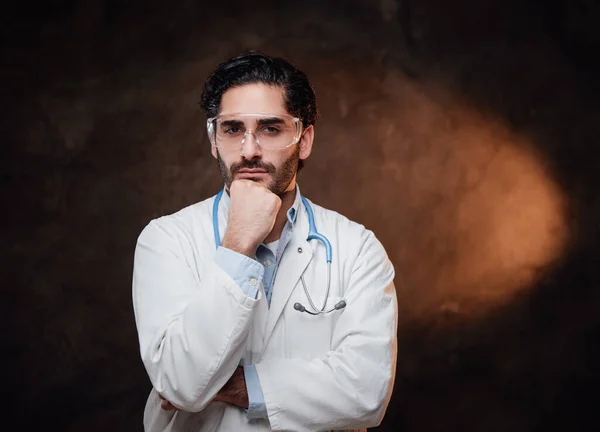 Cirujano de túnica blanca posa con la mano bajo la barbilla —  Fotos de Stock