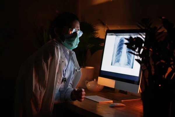 Serious doctor with glasses with computer in dark room — Stock Photo, Image