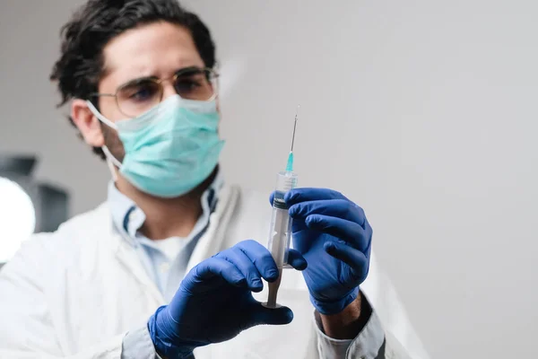 El médico con máscara y guantes en el laboratorio prepara la jeringa —  Fotos de Stock