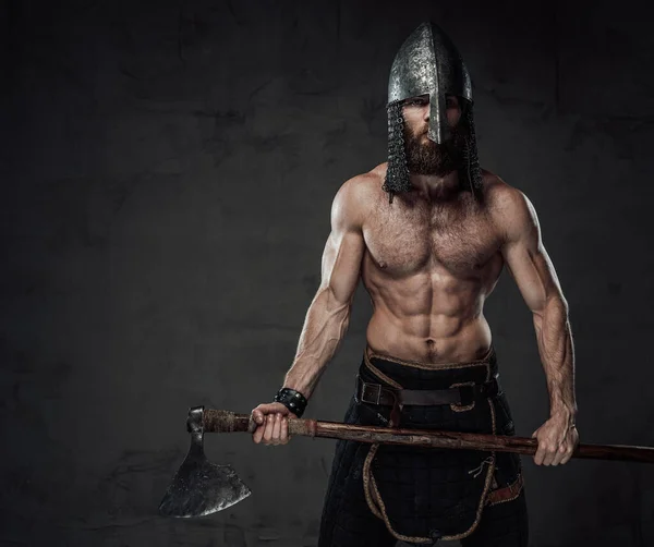 Vikingo sin camisa guerrero con hacha posando en un fondo oscuro — Foto de Stock