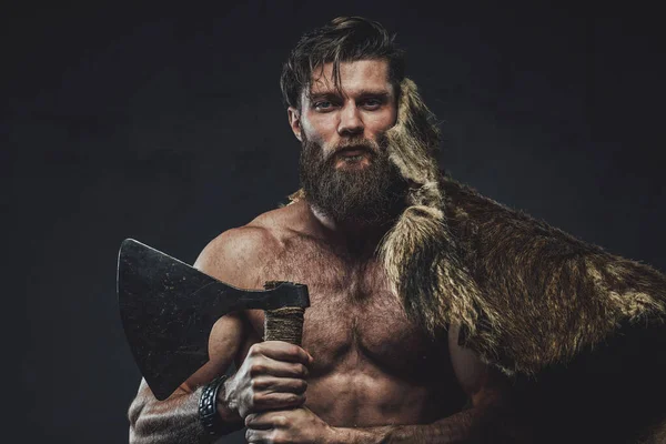 Salvaje y sin camisa vikingo posando en fondo oscuro con hacha —  Fotos de Stock