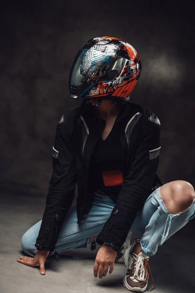 女性バイカーとともにスポーツヘルメットでジャケットポーズで暗い背景 — ストック写真