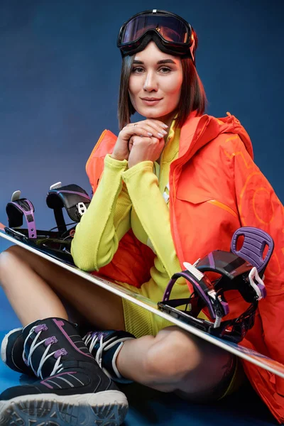 青い背景にスノーボードを持つ美しいスポーツ女性 — ストック写真