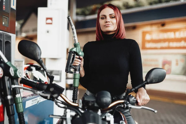 Belleza chica joven está sentado en su bicicleta en la gasolinera — Foto de Stock