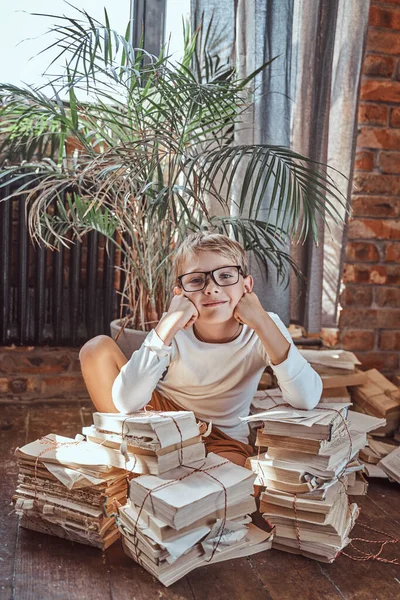 Joyful kind zitten op de vloer in appartement rond boeken — Stockfoto