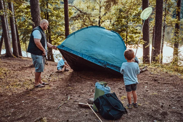 Az óvodások sátrat vertek az apjukkal a nyári erdőben. — Stock Fotó