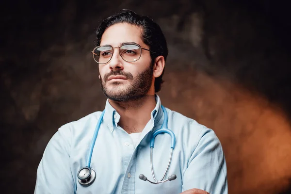 Médico profissional caucasiano em casaco branco em fundo escuro — Fotografia de Stock