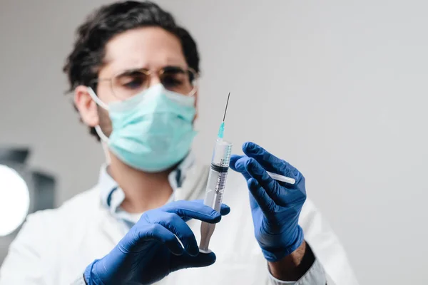 El médico con máscara y guantes en el laboratorio prepara la jeringa —  Fotos de Stock