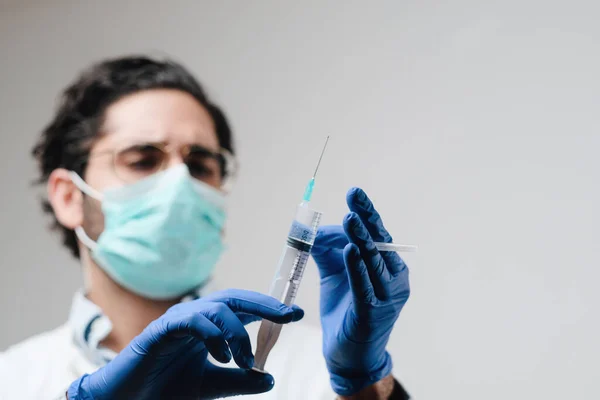 Zaostřený lékař s maskou připravuje injekci v laboratoři — Stock fotografie