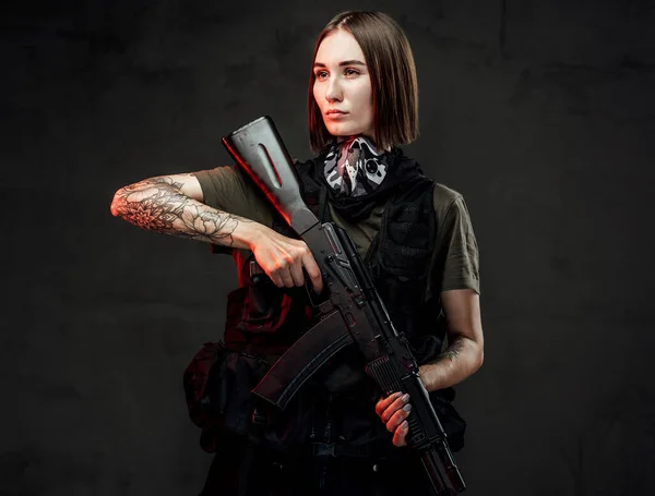 Alegre mercenario femenino con rifle de asalto en fondo oscuro — Foto de Stock