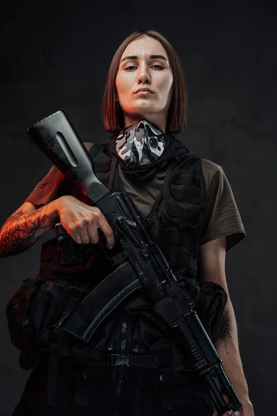 Mulher mercenária alegre com rifle de assalto em fundo escuro — Fotografia de Stock