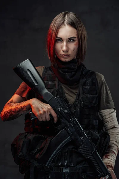 Marcial mulher séria segurando rifle no fundo escuro — Fotografia de Stock