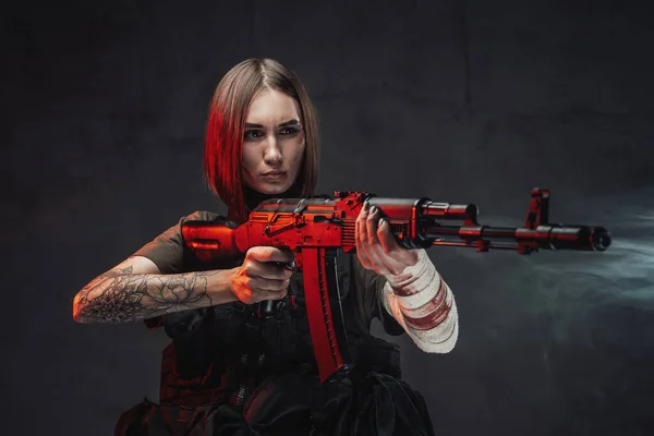 Mujer marcial apuntando con rifle en fondo oscuro y ahumado — Foto de Stock