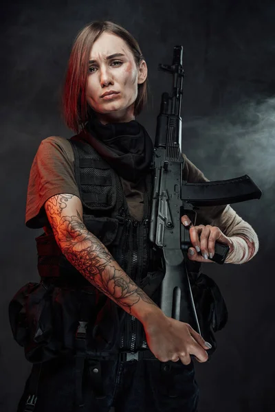 Szomorú női katona puskával a vállán ködös háttérben — Stock Fotó