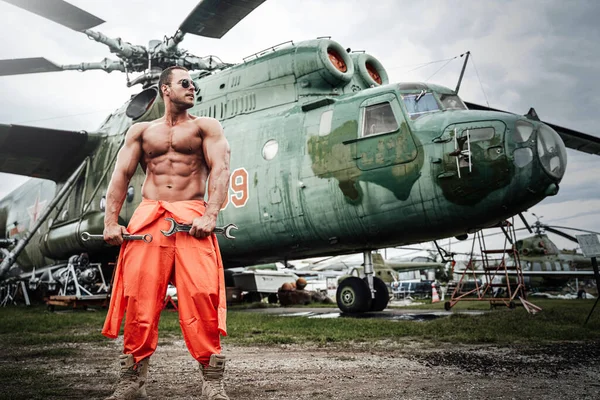 Strumento di tenuta macho muscolare sullo sfondo dell'elicottero — Foto Stock