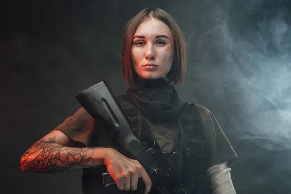 Schöne martialische Frau mit Gewehr im rauchigen und dunklen Hintergrund — Stockfoto
