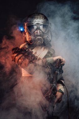Gaz maskeli ve tüfekli genç bir asker.