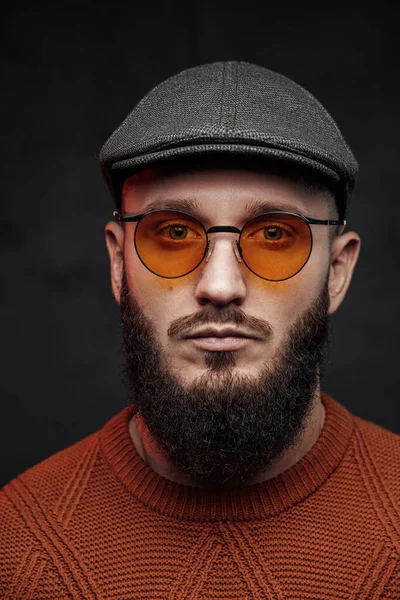 Pozowanie w ciemnym tle brodaty hipster z okularami i czapką — Zdjęcie stockowe