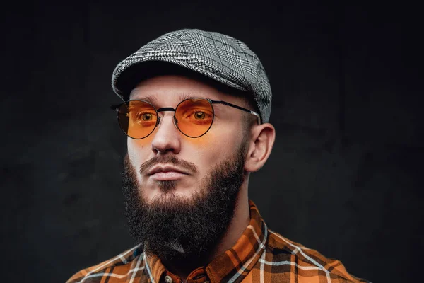 Zdjęcie hipstera z czapką i okularami przeciwsłonecznymi w ciemnym tle — Zdjęcie stockowe