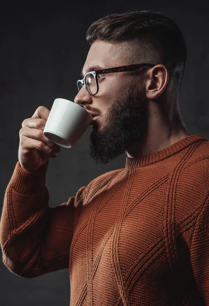 Ciddi sakallı adam koyu arkaplanda kahve içiyor. — Stok fotoğraf