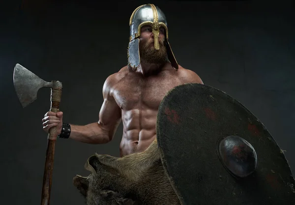 Nordic warrior with axe and shield in studio with spotlight — Stock Photo, Image