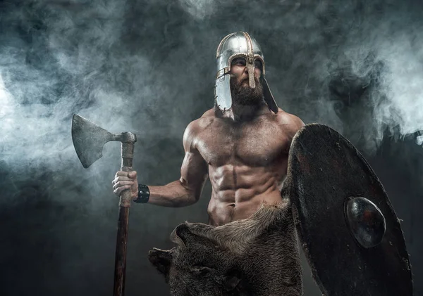 Páncélozott és meztelen viking pózol baltával és pajzzsal a füstben — Stock Fotó