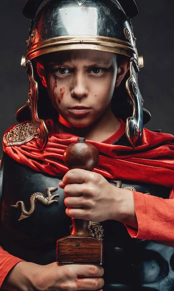 Komoly katonai római fiú karddal sötét háttérben — Stock Fotó