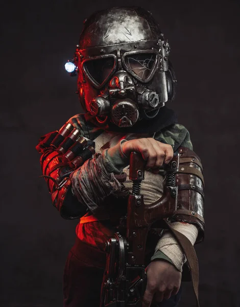 Apocalyptic child with riffle and gas mask stays in dark background — Stock Photo, Image