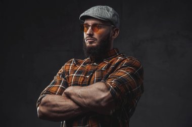 Koyu arkaplanda güneş gözlüklü şık bir hippi.