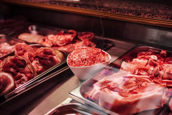 盘中切肉与柜台中生肉的近景 — 图库照片