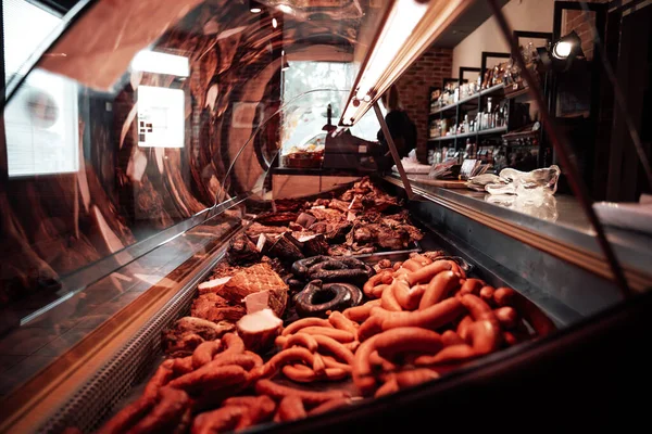 Χασάπηδες κατάστημα σε εσωτερικούς χώρους και τεράστια ποικιλία ακατέργαστου και καπνιστού κρέατος — Φωτογραφία Αρχείου