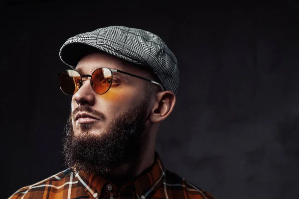 Snímek hlavy hipster s víčkem a slunečními brýlemi v tmavém pozadí — Stock fotografie