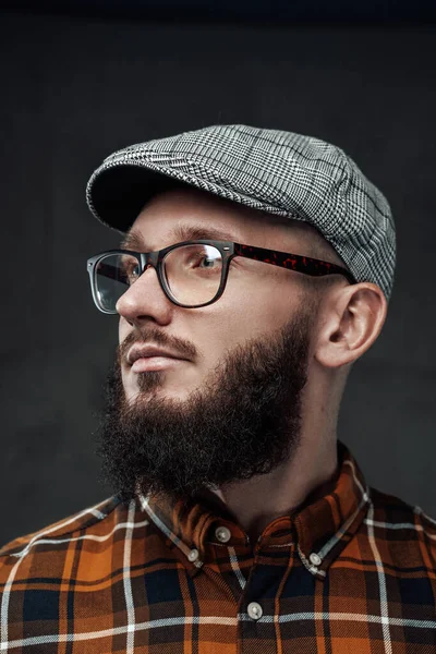 Stylish hipster with beard and glasses in dark background — Stock Photo, Image