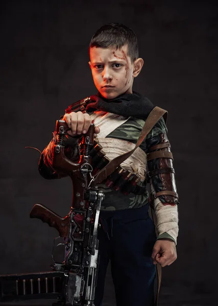 Armed with shotgun kid poses in dark background looking at camera — Stock Photo, Image