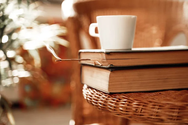Accogliente camera d'albergo con sedia e tavolo con libri e tazza di caffè — Foto Stock